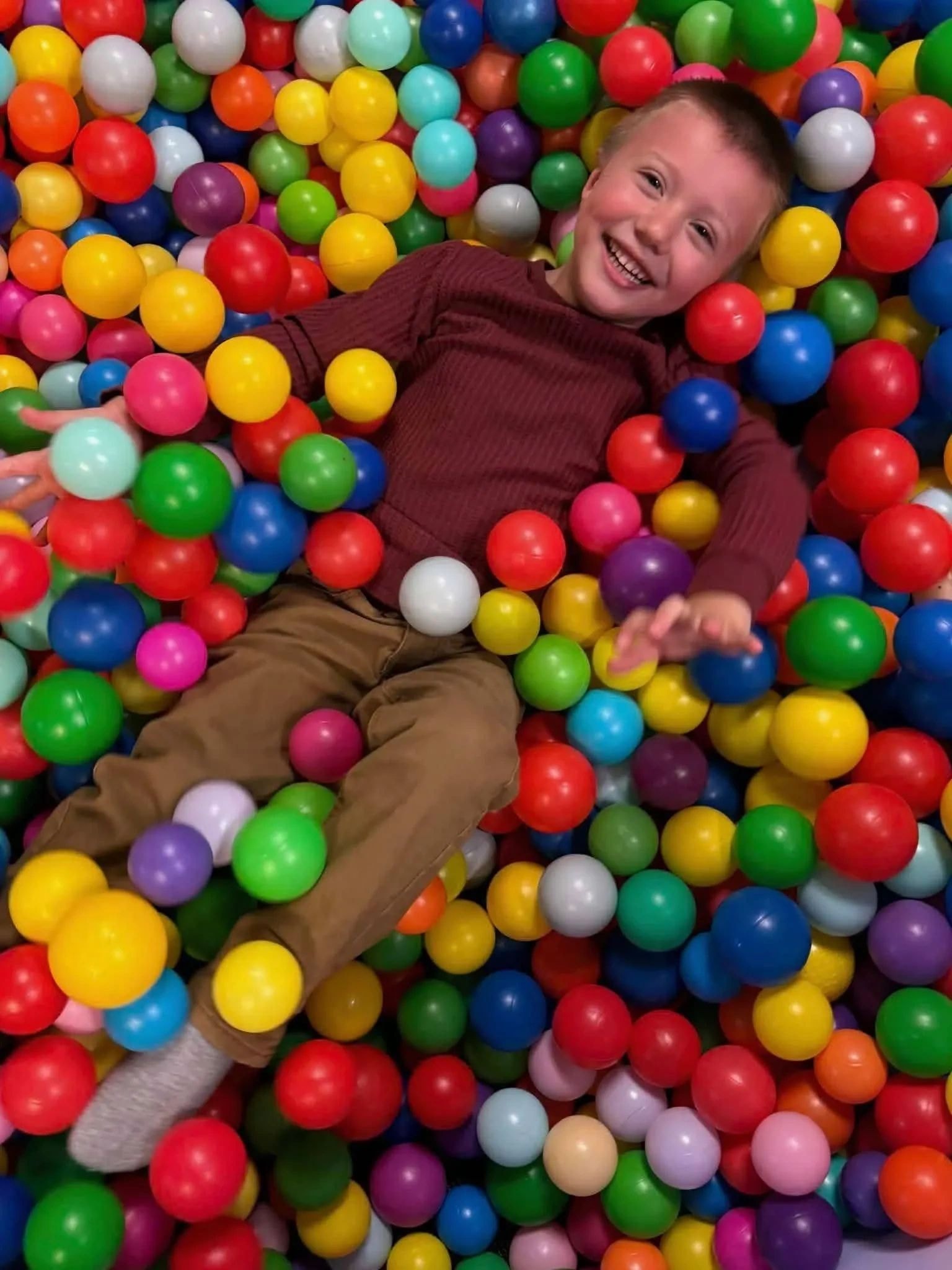Child playing in the ball pit at Let's Go Play